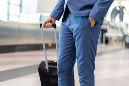 Detail of a businessman pulling a trolley in an airportの写真素材