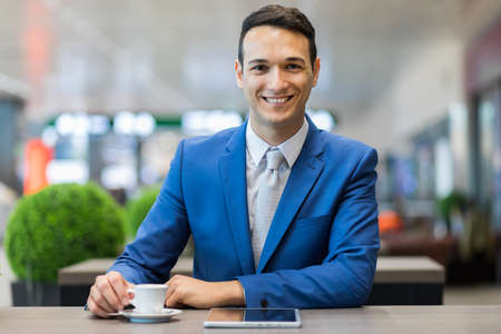 Businessman having breakfast and reading his tabletの写真素材