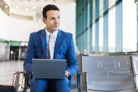 Young businessman working with his laptop in an airportの写真素材