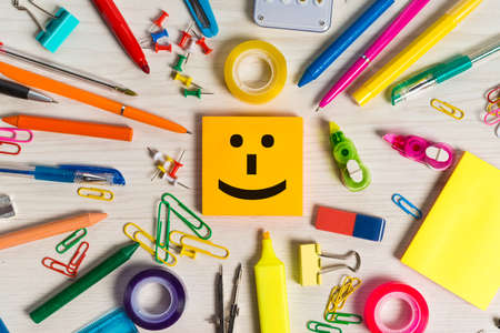 Smiling note emoticon and stationery around itの写真素材