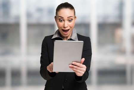 Surprised woman using her digital tabletの写真素材