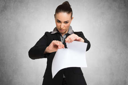 Angry businesswoman destroying a documentの写真素材