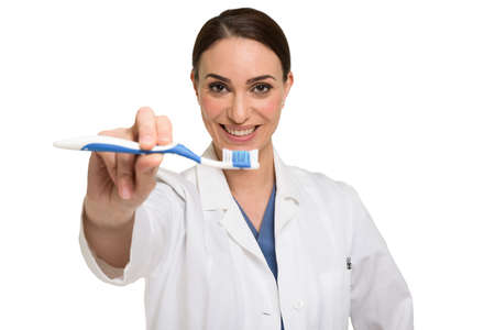 Dentist showing a toothbrush. Isolated on whiteの写真素材