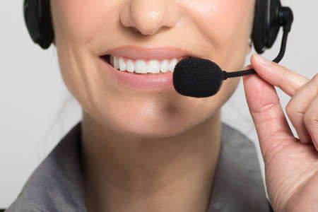 Beautiful consultant of call center in headphones on white backgroundの写真素材