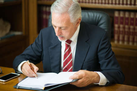Businessman reading a book in his studioの写真素材