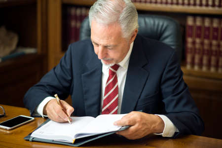 Businessman writing a note in his officeの写真素材