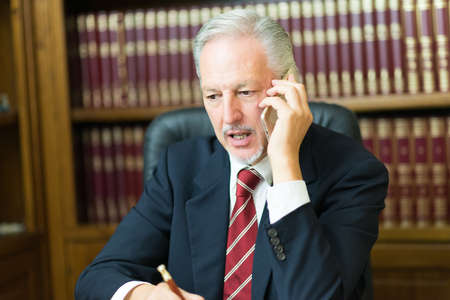 Businessman talking phone in officeの写真素材