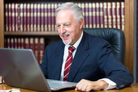 Businessman using his laptop in a libraryの写真素材