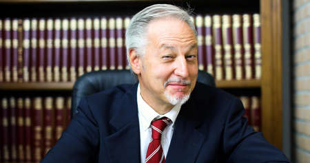 Portrait of smiling senior businessman in his libraryの写真素材