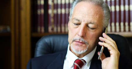 Cheerful man in office answering the phoneの写真素材