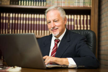 Happy businessman using his laptop in his studioの写真素材