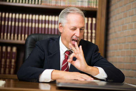 Senior businessman giving ok signの写真素材