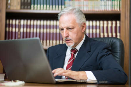 Businessman using his laptop in a libraryの写真素材