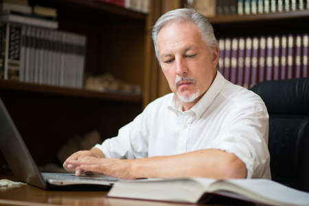 Businessman using his laptop in a libraryの写真素材