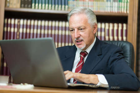 Businessman using his laptop in a libraryの写真素材