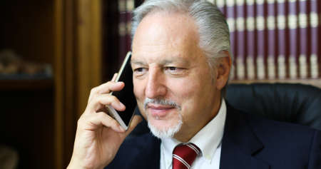 Cheerful man in office answering the phoneの写真素材