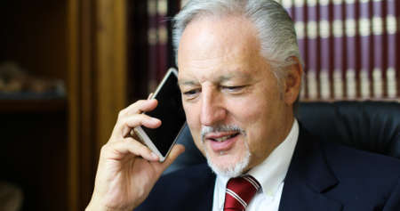 Cheerful man in office answering the phoneの写真素材