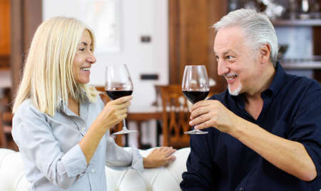 Mature couple toasting wine glasses to celebrate a special occasionの写真素材