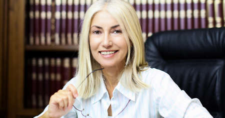 Portrait of a mature businesswoman smiling in her libraryの写真素材