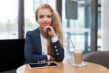 Young businesswoman on a coffee break. Using tablet computer.の写真素材