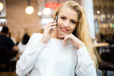 Portrait of a young woman talking on the phone on a breakの写真素材