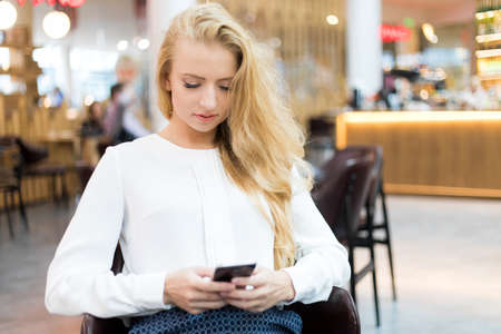 Young businesswoman using her smartphone to browse web content and sending messagesの写真素材