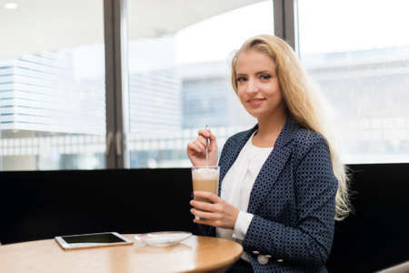 Beautiful woman having a coffee in a cafeの写真素材
