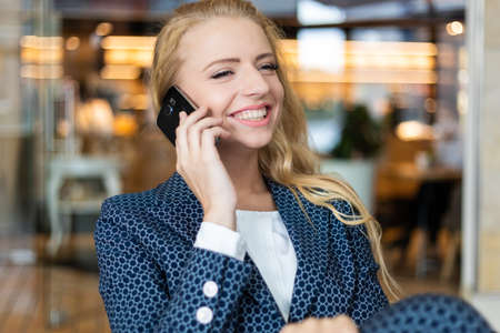 Portrait of a young woman talking on the phone on a breakの写真素材