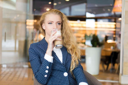 Beautiful woman having a coffee in a cafeの写真素材