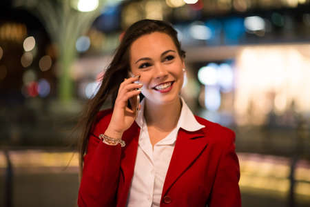 Woman talking on her mobile phone at nightの写真素材