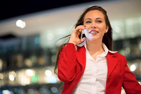 Woman talking on her mobile phone at nightの写真素材