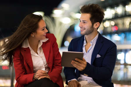 Couple of business people using a tablet outdoorの写真素材