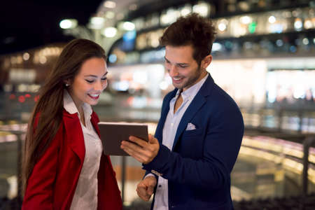 People using tablet at night in a cityの写真素材