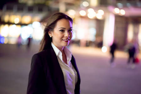 Businesswoman walking in a city at night timeの写真素材