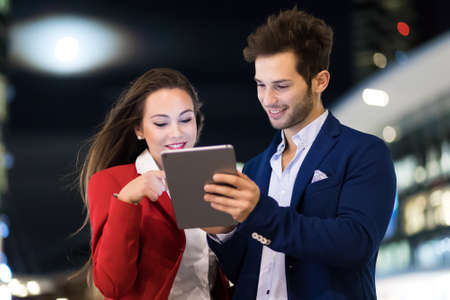 Couple of business people using a tablet outdoorの写真素材