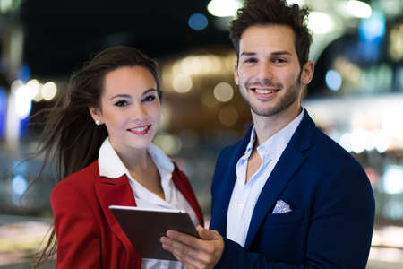 Couple of business people using a tablet outdoorの写真素材