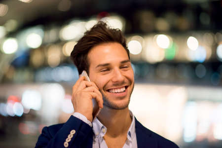 Young handsome man talking on the cell hone at night