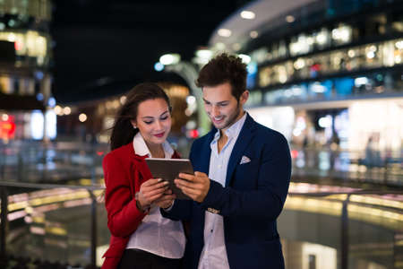 People using tablet at night in a cityの写真素材