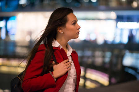 Woman walking in a city at night timeの写真素材