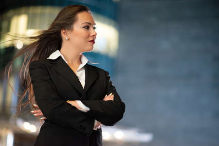 Young businesswoman portrait in a modern city setting at nightの写真素材