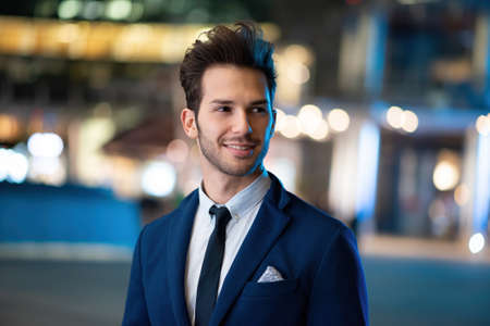 Business man night portrait in a cityの写真素材