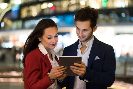 Couple of business people using a tablet outdoorの写真素材