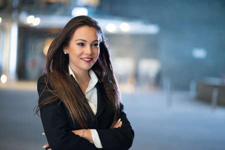 Young businesswoman portrait in a modern city setting at nightの写真素材