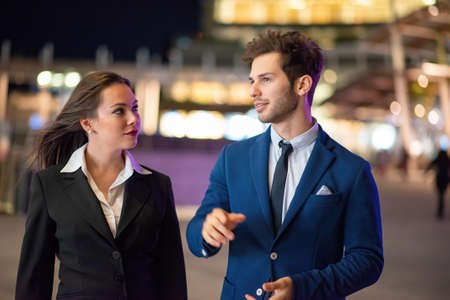 Business partners discussing together late in the evening in a modern city setting