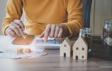 Image Young asian woman using smartphone calculator calculate loan in home, concept finance business investment property. selective focusの写真素材