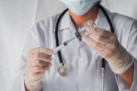 Doctor, nurse or scientist in laboratory holding a syringe with liquid vaccines. Concept fight and...