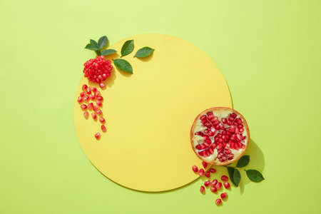 Empty podium for cosmetics with ingredients of red pomegranate extract and pomegranate seeds, flakes...