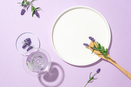 A white ceramic plate, water glass, and fresh lavender pop against a pastel purple backdrop. Ample copy space for product display. Harness the power of natural extract.の写真素材