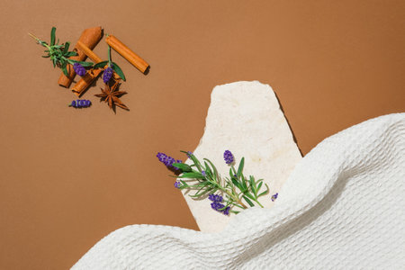 An unlabeled perfume bottle and a glass rod are placed on a stone platform with lavender flowers and herbs on a brown background. Perfume advertising.の写真素材