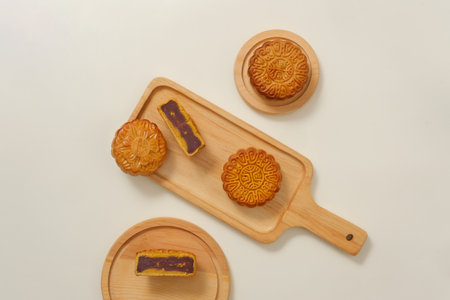High view of appetizing mooncakes displayed on wooden trays on white background. Mooncakes...